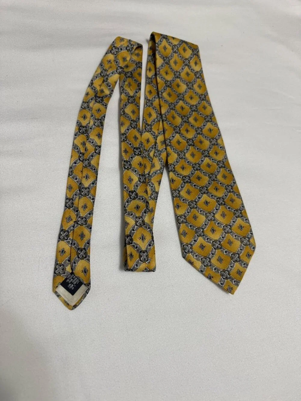 This is a vintage Ketch geometric medallion silk necktie, featuring a distinct g
